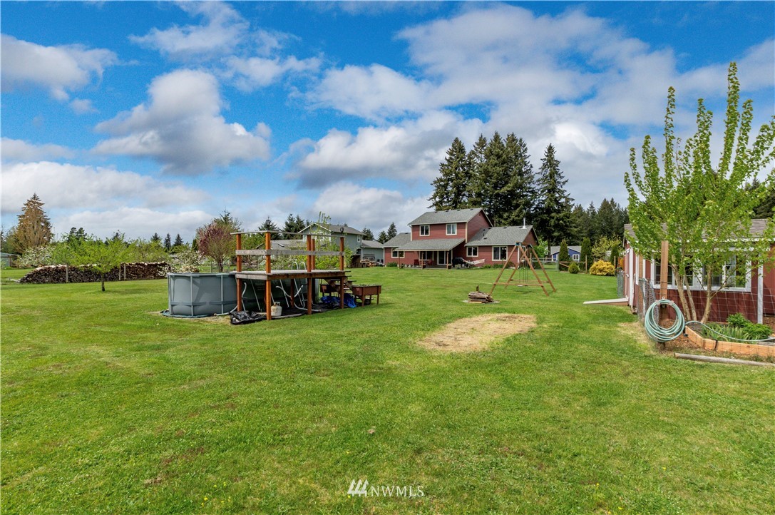 6519 190th Trail Southwest Rochester, WA 98579 - Photo 35 of 40 a view of a house with a big yard and large trees