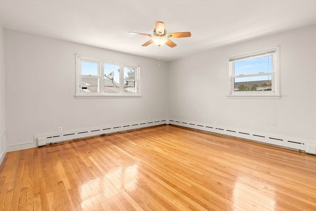 a view of a room with wooden floor and a ceiling fan