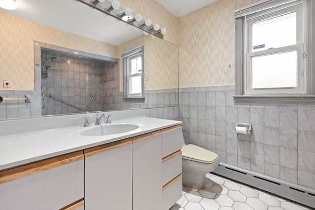 a bathroom with a granite countertop sink a toilet and a mirror