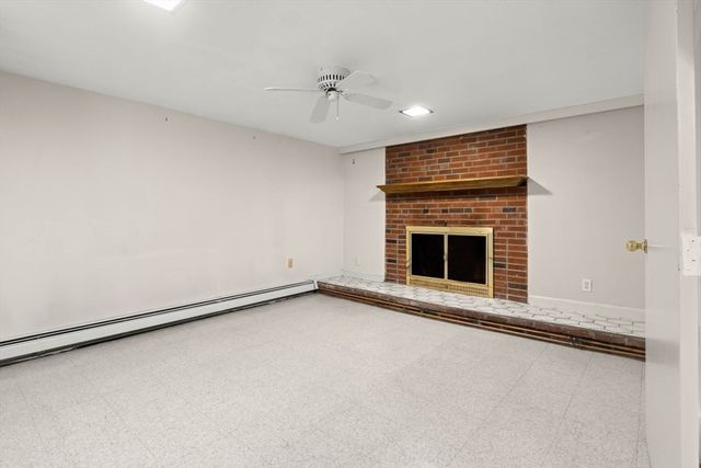 a view of an empty room with a fireplace and a window