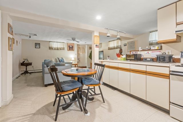 a kitchen with a dining table chairs and white cabinets