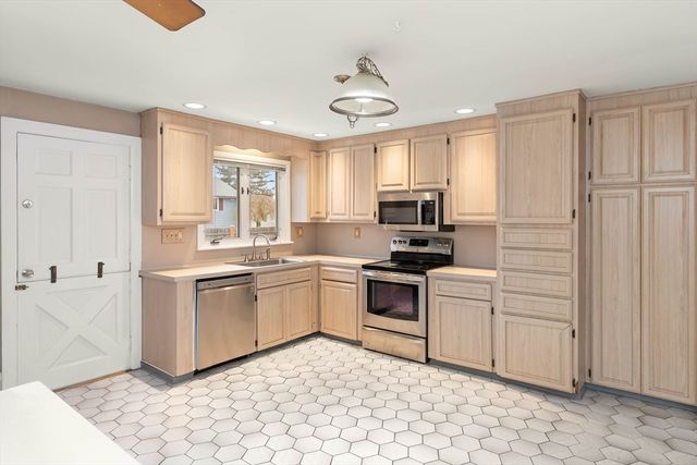 a kitchen with white cabinets and white appliances
