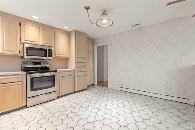 a kitchen with a stove a microwave and white cabinets
