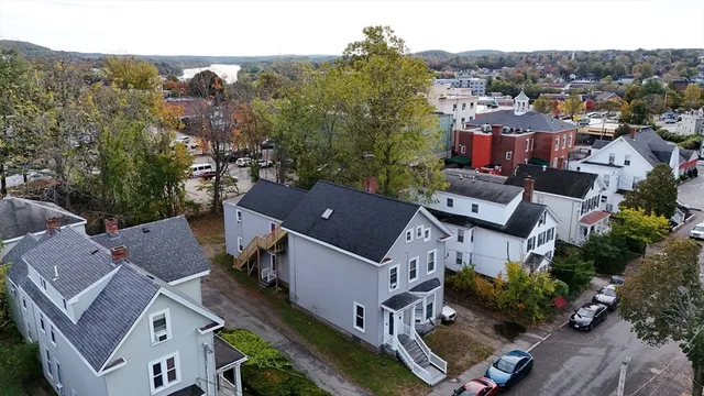 a view of a house with a yard and a large tree