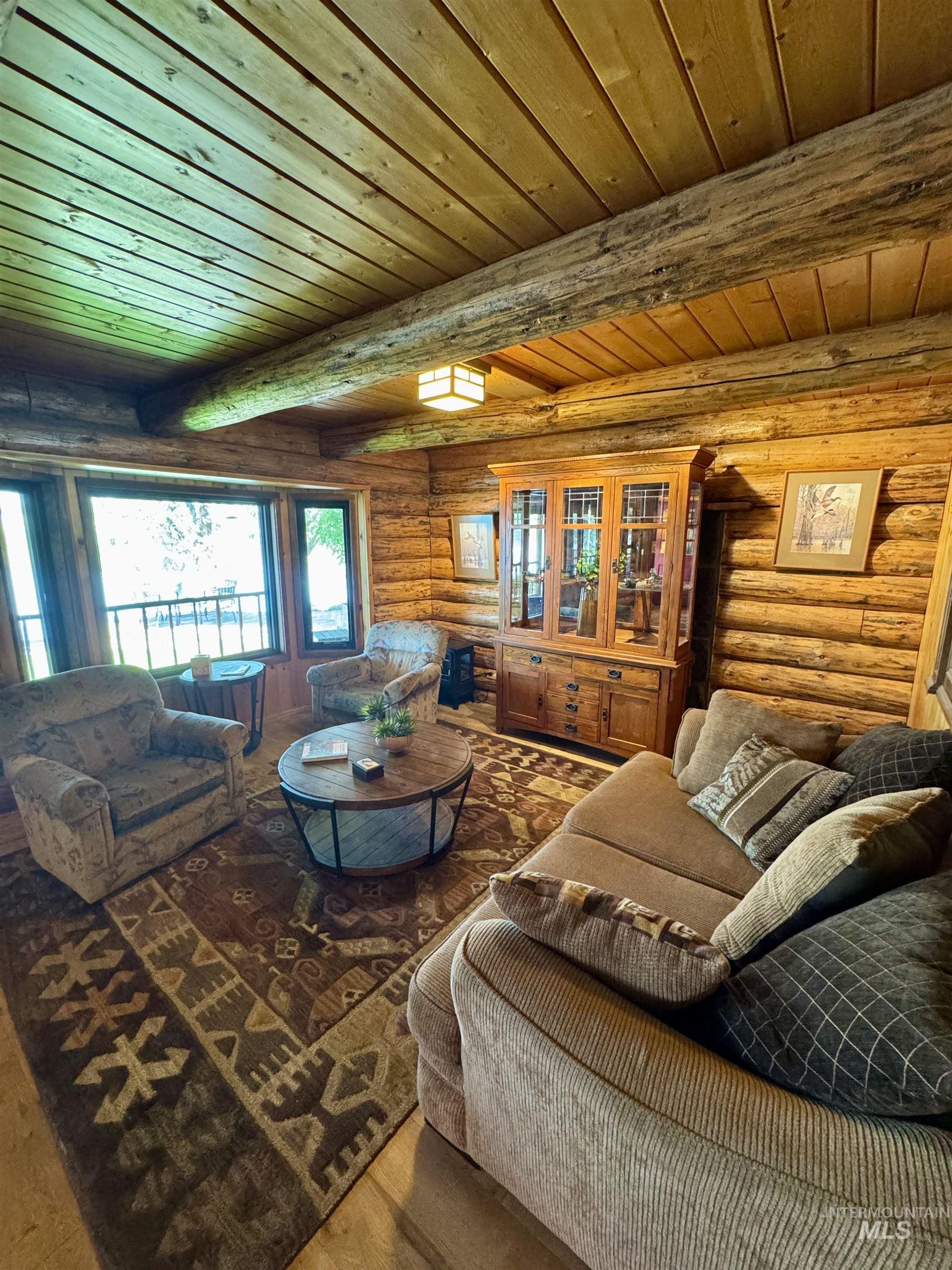 62 Bell Rapids Road Hagerman, ID 83332 - Photo 11 of 34 Expansive living area featuring natural log walls, wood-finish flooring, and a planked wood ceiling