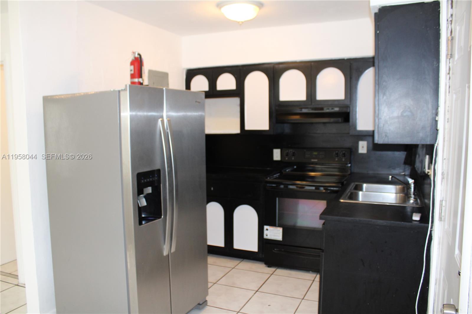 1601 Northwest 81st Street, Unit 1601 Miami, FL 33147 - Photo 3 of 13 a kitchen with stainless steel appliances granite countertop a refrigerator a stove and a sink