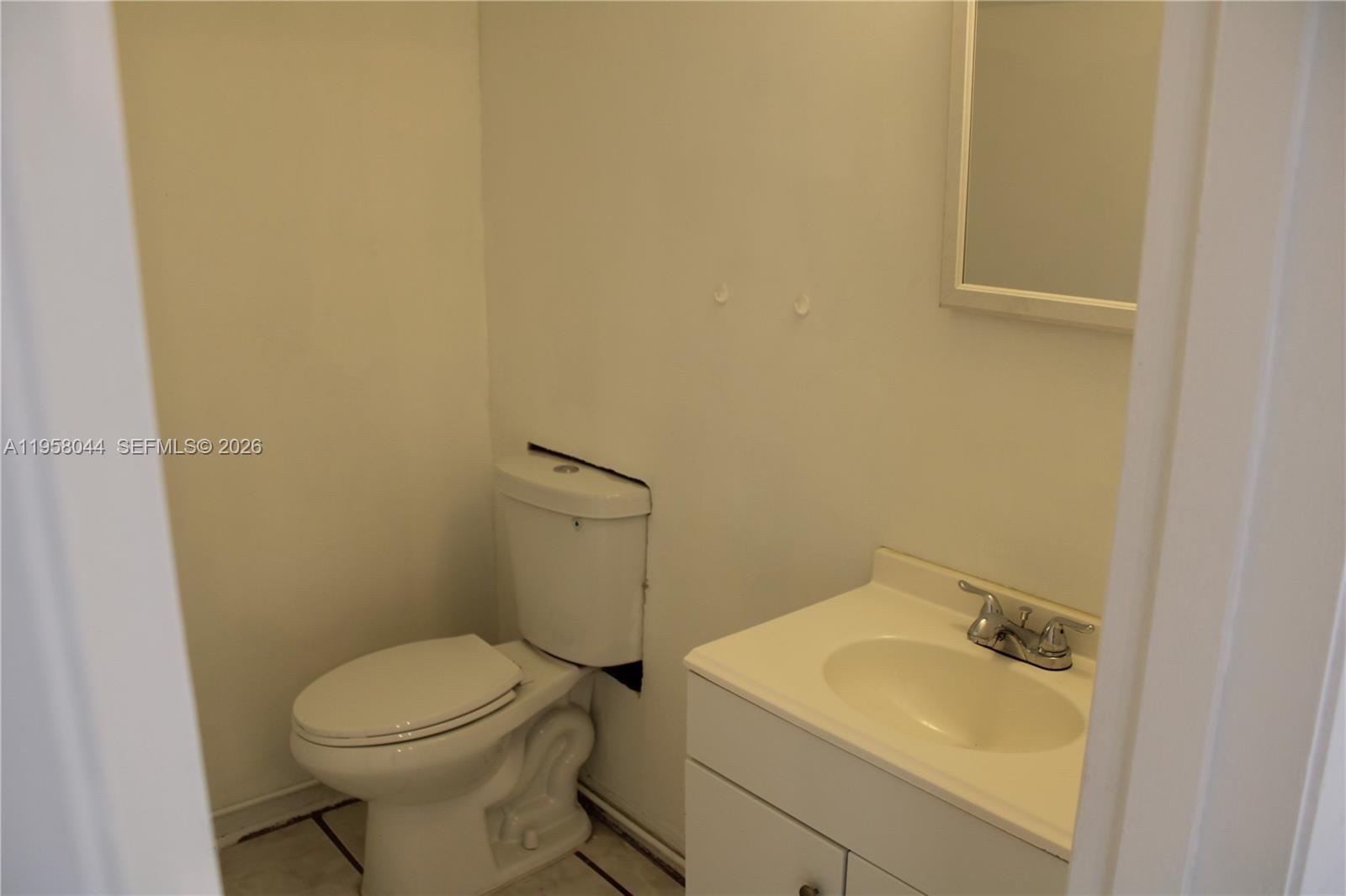 1601 Northwest 81st Street, Unit 1601 Miami, FL 33147 - Photo 5 of 13 a white toilet sitting next to a white sink and a sink