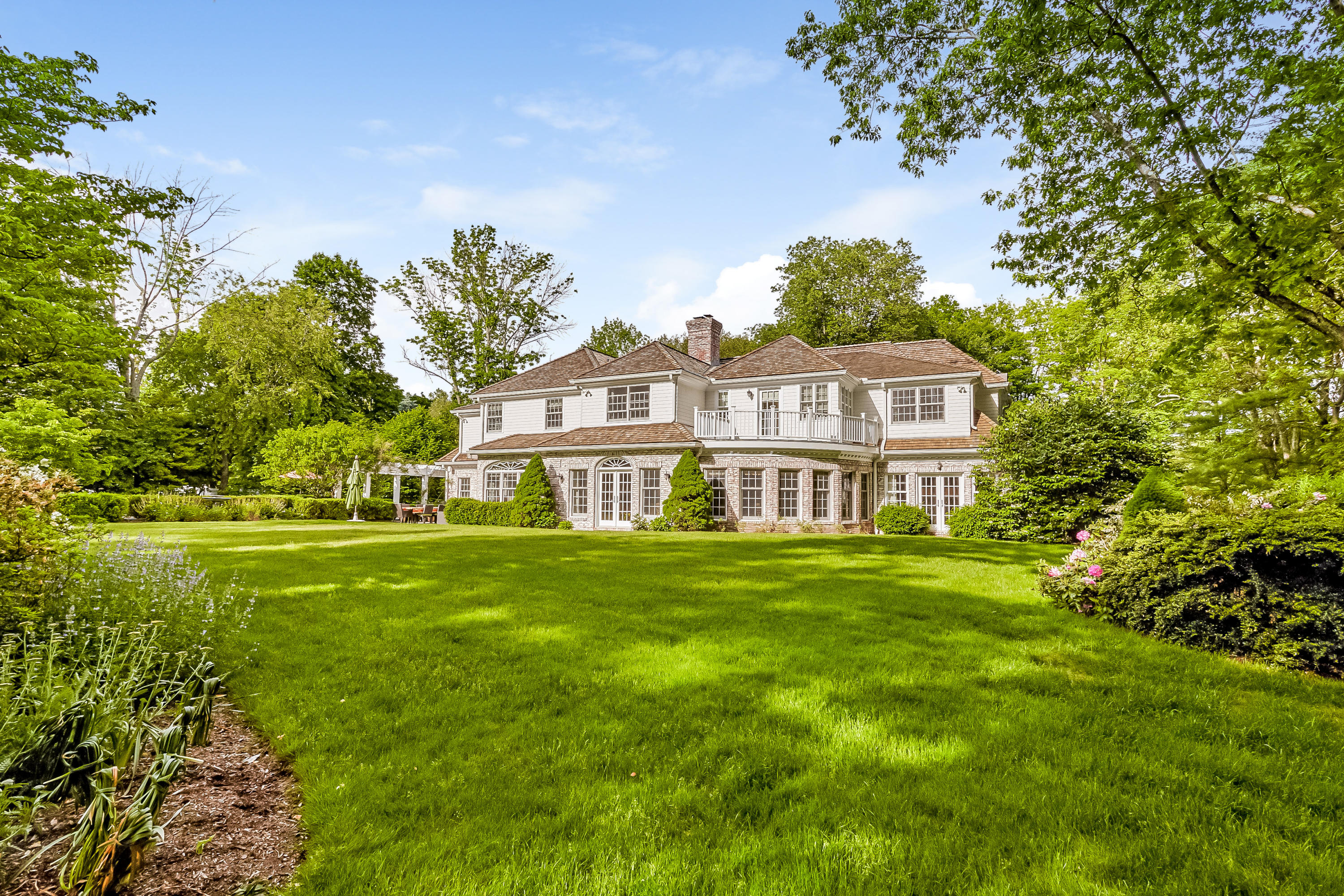741 Hollow Tree Ridge Road Darien, CT 06820 - Photo 52 of 60 a view of a big yard next to a house with a garden