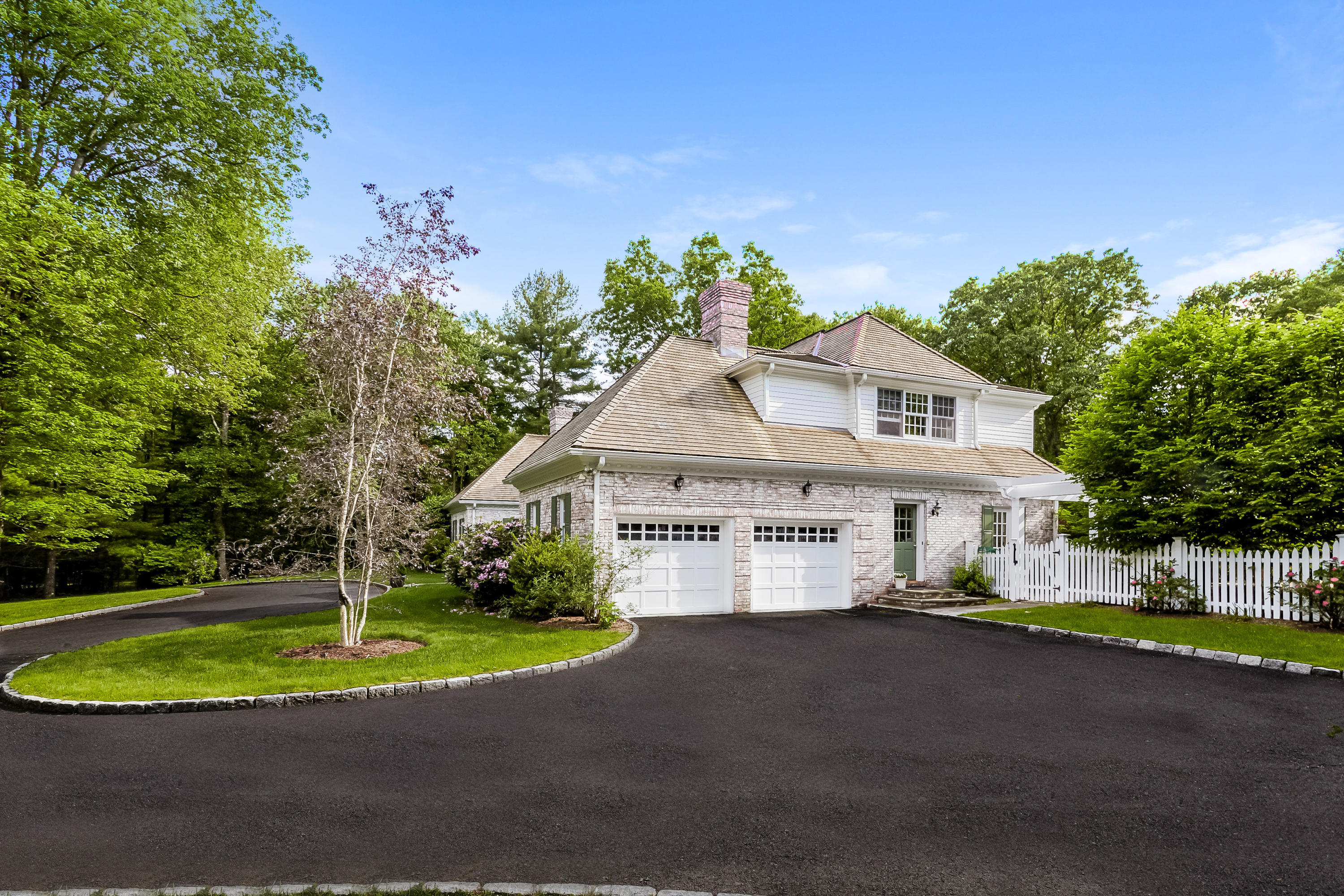 741 Hollow Tree Ridge Road Darien, CT 06820 - Photo 56 of 60 a front view of a house with a garden and trees