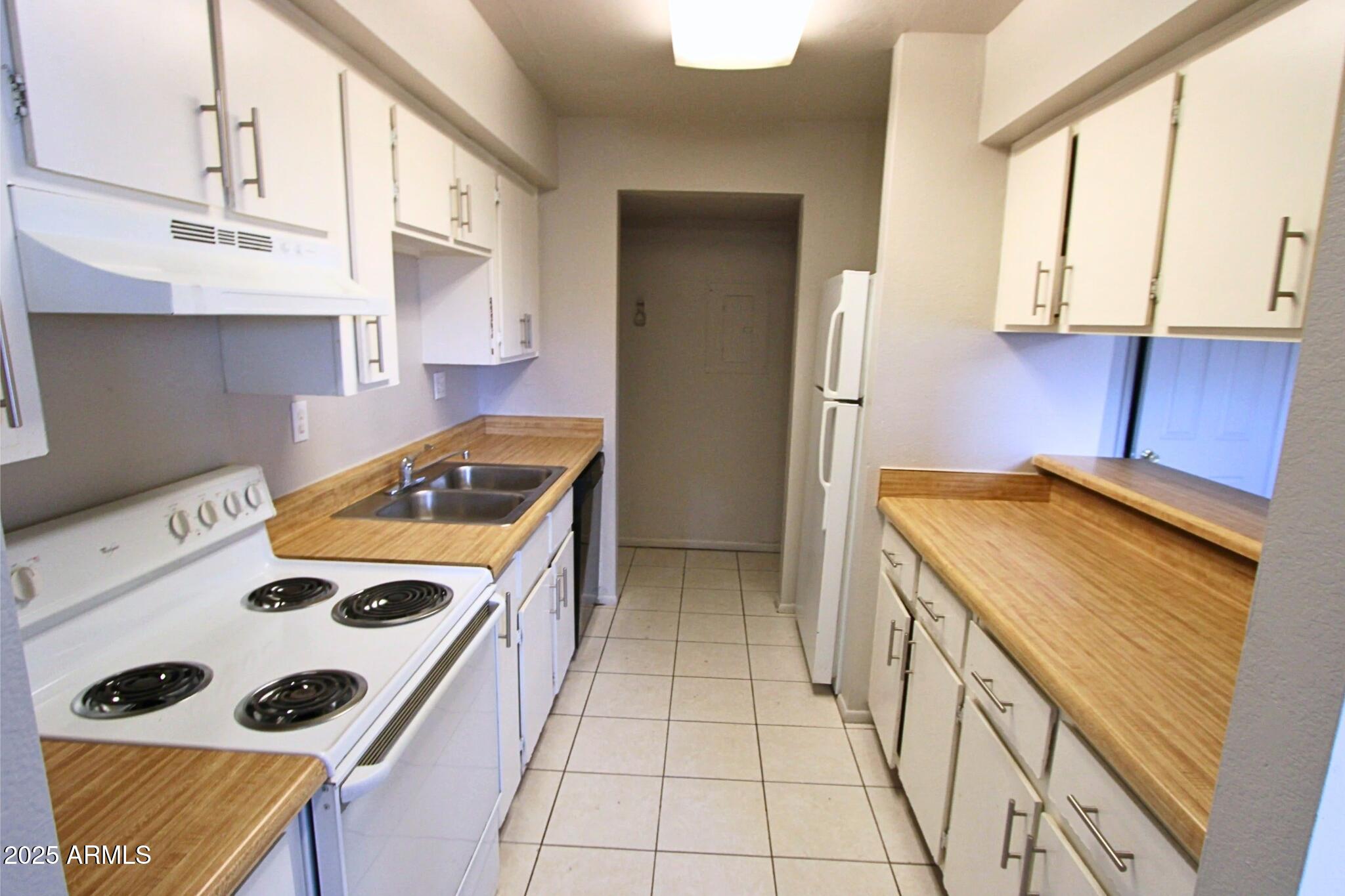 410 East 9th Avenue, Unit 1 Mesa, AZ 85204 - Photo 7 of 17 a kitchen with a stove a sink and a refrigerator