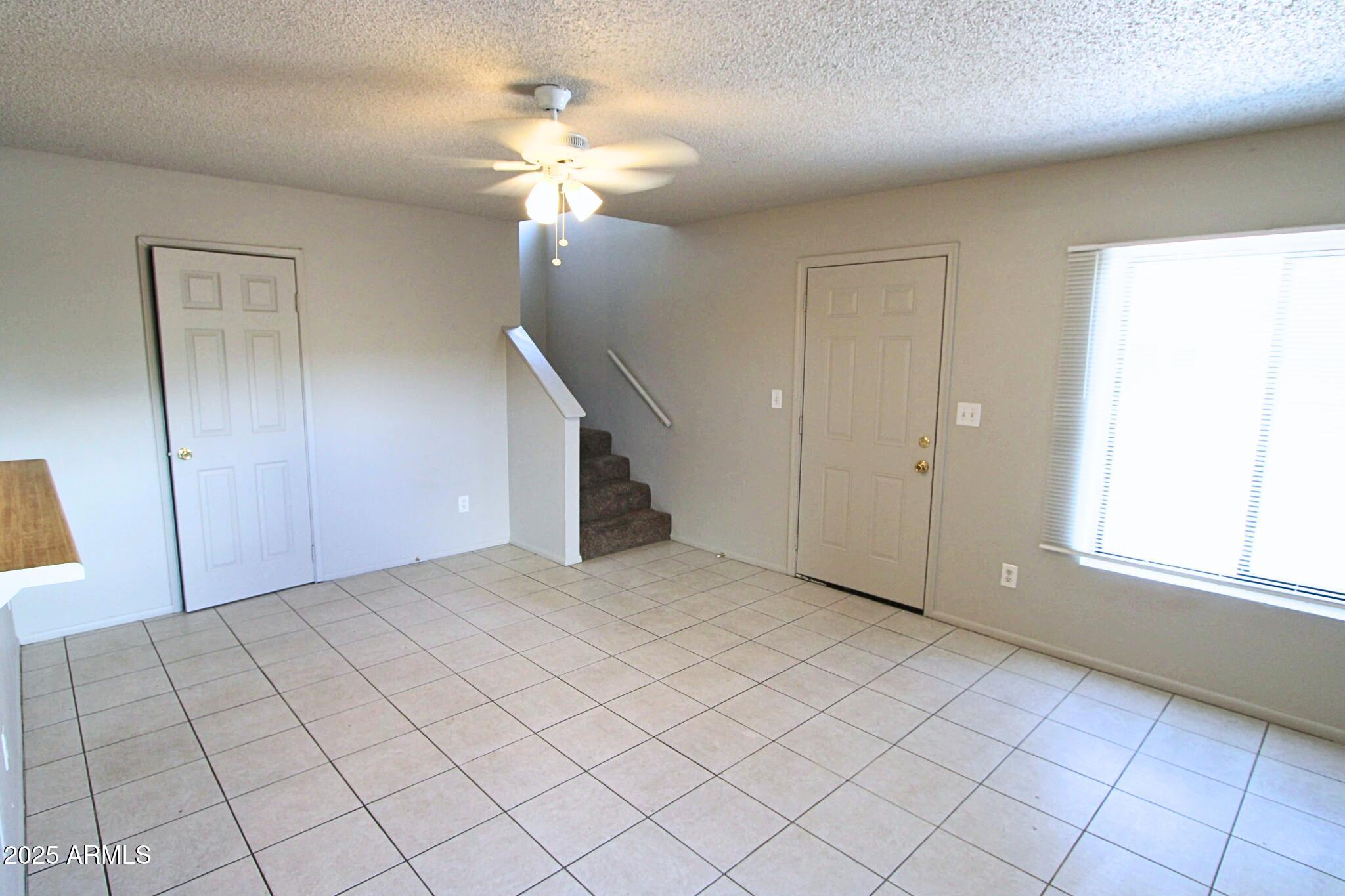 410 East 9th Avenue, Unit 1 Mesa, AZ 85204 - Photo 9 of 17 an empty room with chandelier fan and windows