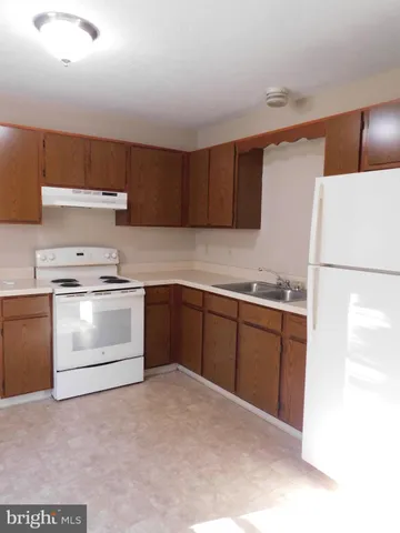 a kitchen with a cabinets and white appliances