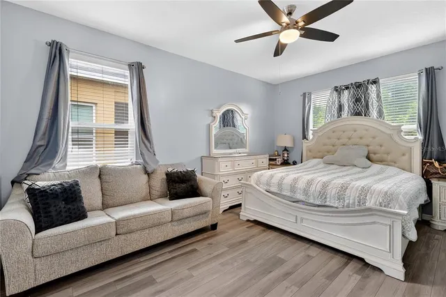 a bedroom with a large bed couch and a window