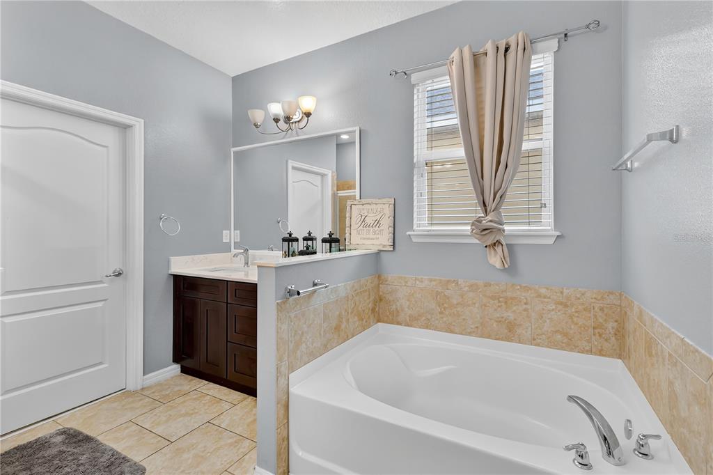 1938 Commander Way Kissimmee, FL 34746 - Photo 12 of 30 a bathroom with a tub sink and mirror