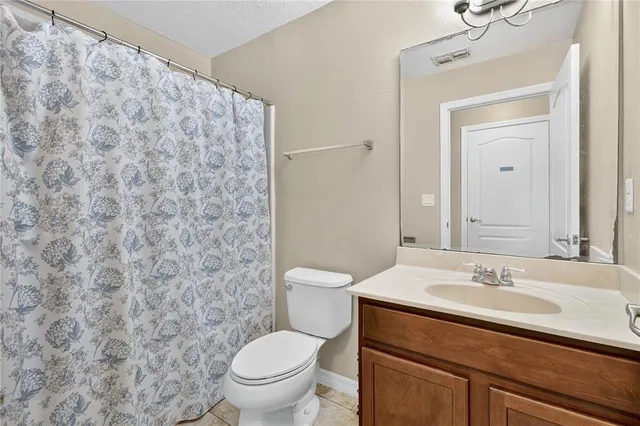 a bathroom with a granite countertop toilet a sink and a mirror
