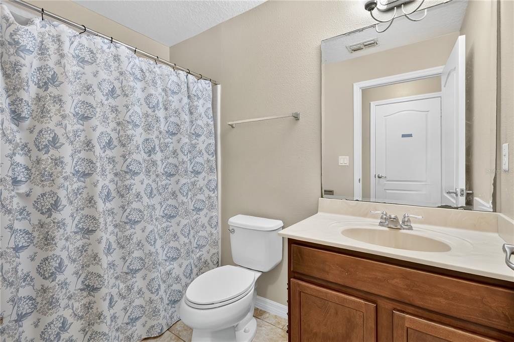 1938 Commander Way Kissimmee, FL 34746 - Photo 16 of 30 a bathroom with a granite countertop toilet a sink and a mirror