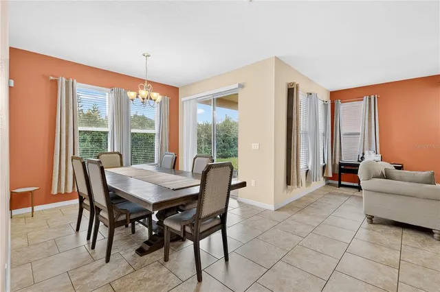 a dining room with furniture and large windows