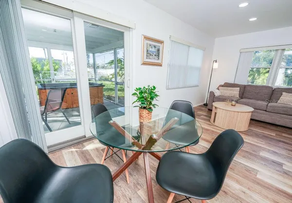 a dining room with furniture a potted plant and wooden floor