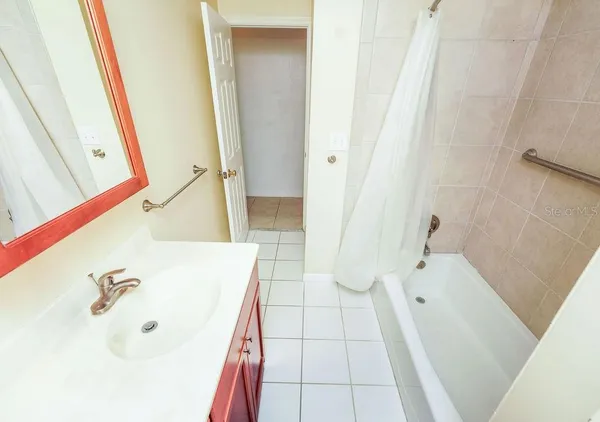 a bathroom with a tub a sink and a mirror