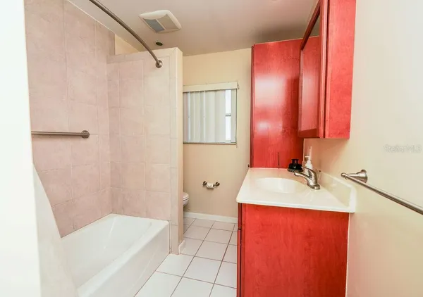 a bathroom with a tub sink and mirror