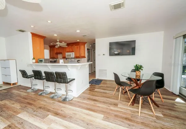a living room with furniture a flat screen tv and kitchen view