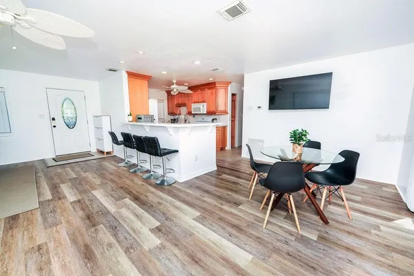 a living room with furniture a flat screen tv and kitchen view
