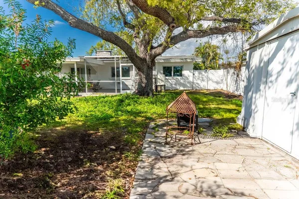 a view of a chair and tables in the back yard of the house