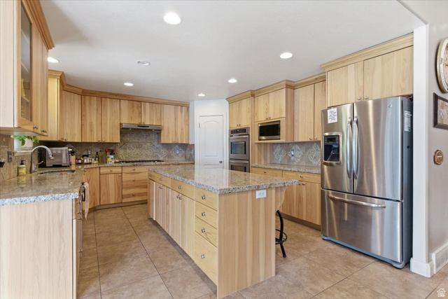 6237 West 4600th Street South Hooper, UT 84315 - Photo 13 of 48 Kitchen featuring light wood finish cabinets, stainless steel appliances, light stone counters, light tile patterned floors, and recessed lighting