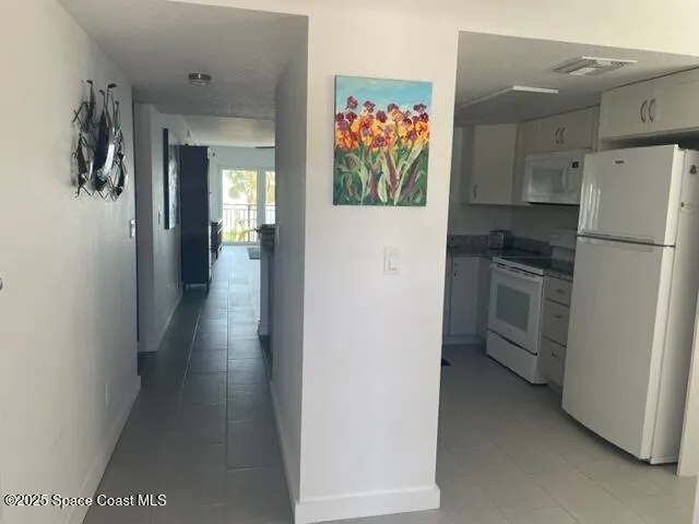 a view of a hallway with a refrigerator and a stove