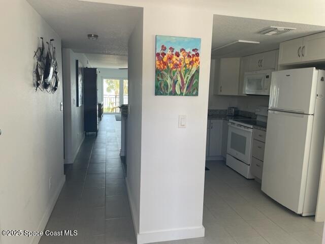 3901 Dixie Highway Northeast, Unit 210 Palm Bay, FL 32905 - Photo 2 of 9 a view of a hallway with a refrigerator and a stove