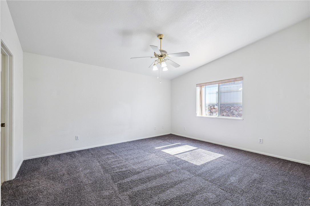 2524 South Ridge Avenue Bullhead City, AZ 86429 - Photo 27 of 64 Carpeted spare room with a ceiling fan, vaulted ceiling, and baseboards