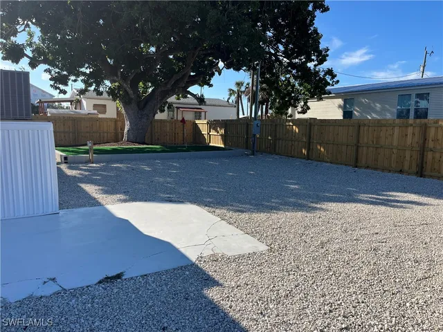 a front view of a house with a yard and tree
