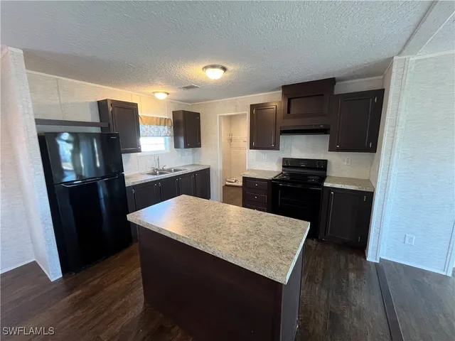 a kitchen with a refrigerator and a stove top oven