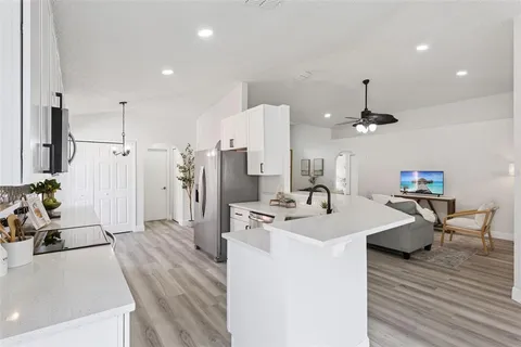 a kitchen with stainless steel appliances kitchen island granite countertop a sink refrigerator and cabinets