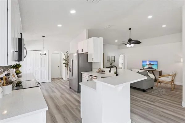 a kitchen with stainless steel appliances kitchen island granite countertop a sink refrigerator and cabinets