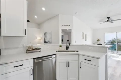 a kitchen with cabinets appliances a sink and a counter top space