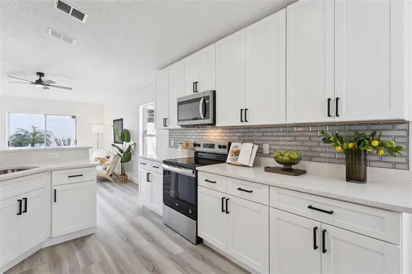 a kitchen with white cabinets and appliances