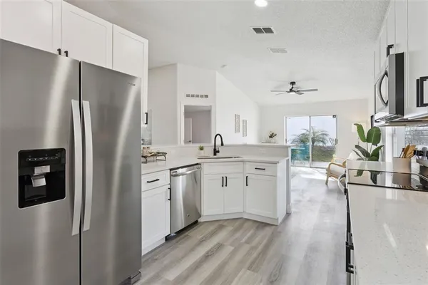 a kitchen with white cabinets and stainless steel appliances