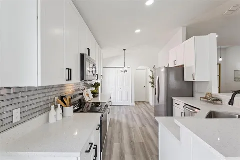 a kitchen with stainless steel appliances kitchen island granite countertop a refrigerator and a stove