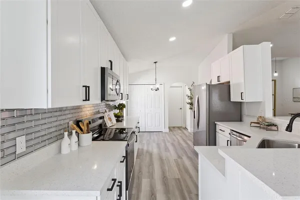 a kitchen with stainless steel appliances kitchen island granite countertop a refrigerator and a stove