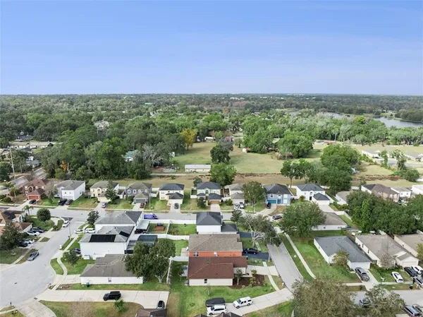 an aerial view of residential houses with outdoor space and trees