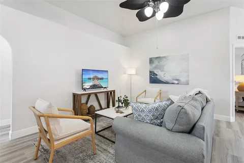 a living room with furniture and a wooden floor
