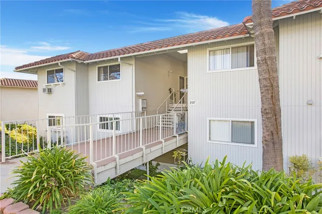a view of a house with a small yard and wooden fence