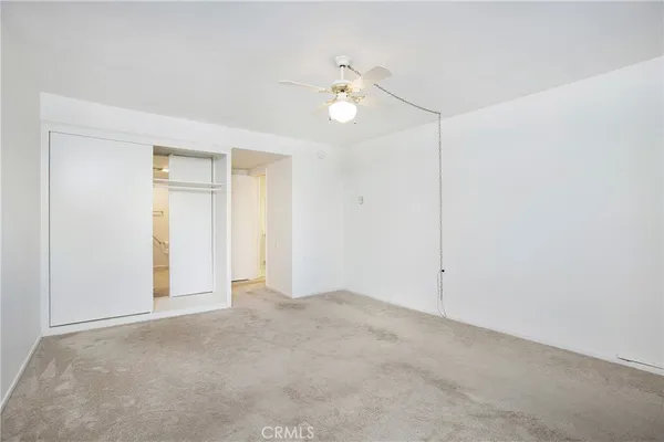 a view of an empty room with a ceiling fan