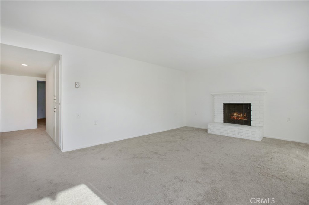 2137 Ronda Granada, Unit A Laguna Woods, CA 92637 - Photo 3 of 16 an empty room with a fireplace