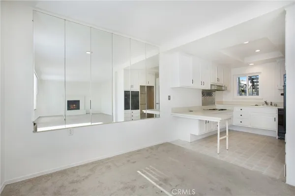 a large white kitchen with a stove a sink and a refrigerator