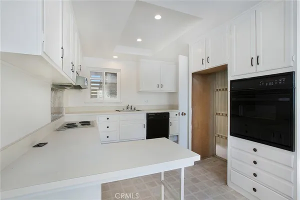 a kitchen with white cabinets and appliances