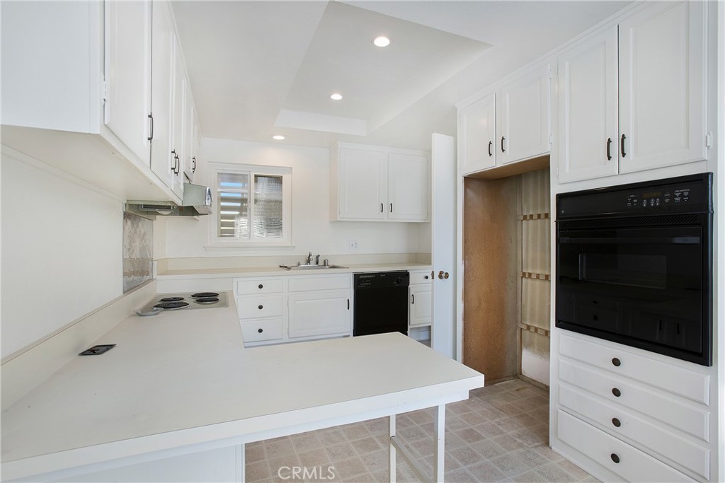 2137 Ronda Granada, Unit A Laguna Woods, CA 92637 - Photo 8 of 16 a kitchen with white cabinets and appliances