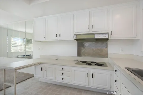 a kitchen with granite countertop white cabinets and white appliances