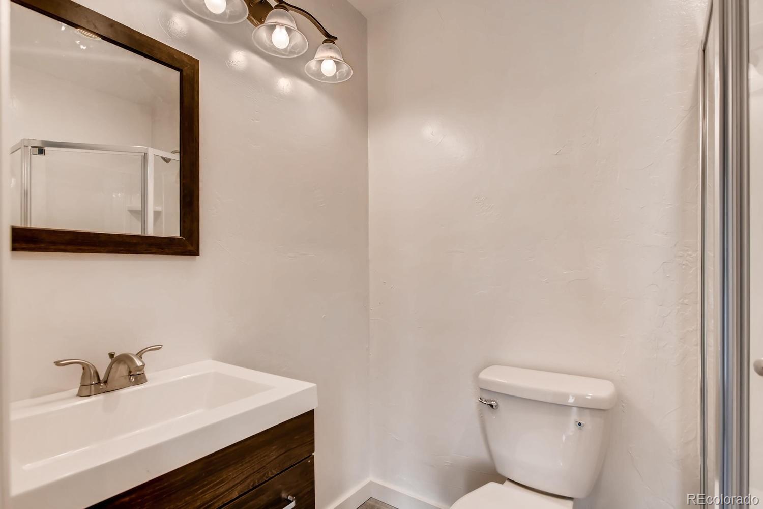 217 Bishop Road Bailey, CO 80421 - Photo 10 of 15 a bathroom with a sink a toilet and mirror